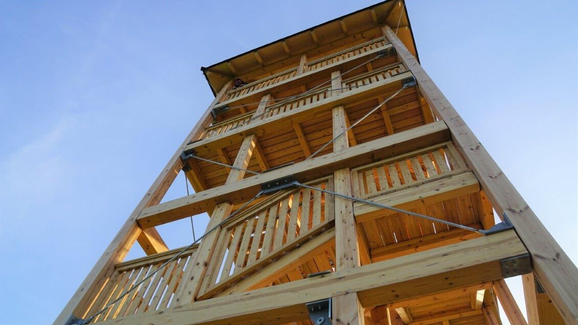 Ein hoher Aussichtsturm aus Holz mit mehreren Etagen. Der Himmel im Hintergrund ist klar und blau. | © Gemeinde Unterlamm