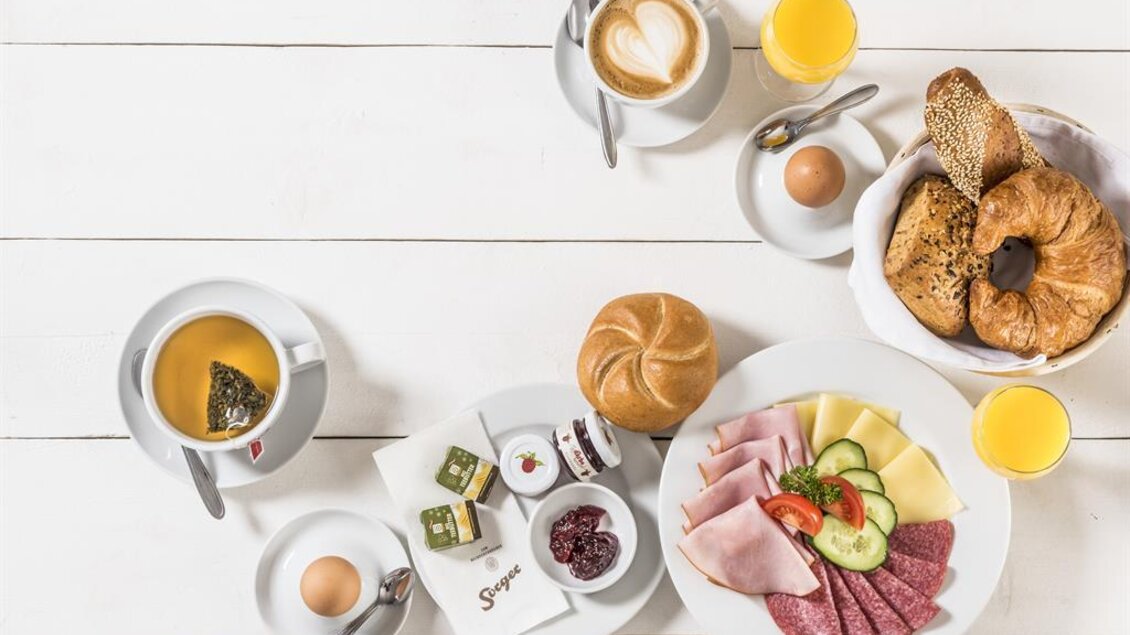 Frühstück in der Bäckerei Sorger in Voitsberg mit Gebäck, Aufschnitt, Käse, Kaffee und Orangensaft auf einem weiß gedeckten Tisch. | © Werner Krug