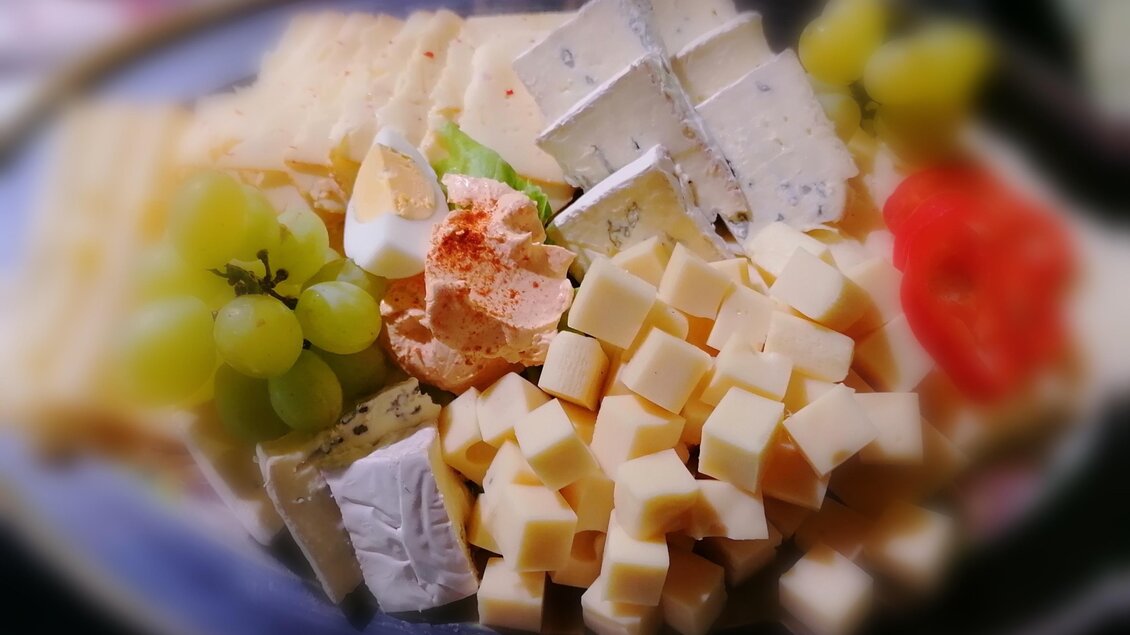Ein köstlicher Käseplattenmix mit verschiedenen Käsesorten, Trauben und Tomaten. Ideal für eine Snack- oder Partypräsentation. | © Günter Ludwig Kämmerer