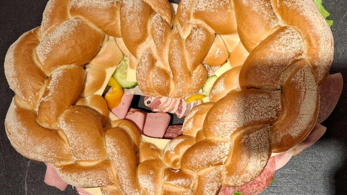 Ein Herz aus geflochtenem Brot, gefüllt mit verschiedenen Aufschnittsorten und Gemüse. Es ist kreativ und ansprechend angerichtet. | © Günter Ludwig Kämmerer