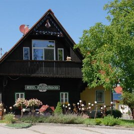 Ein charmantes, traditionelles Holzhaus mit einem grünen Garten. Die Umgebung ist hell und sonnig, ideal für einen ruhigen Aufenthalt. | © Bäuerliches Kunst- und Kleinhandwerk