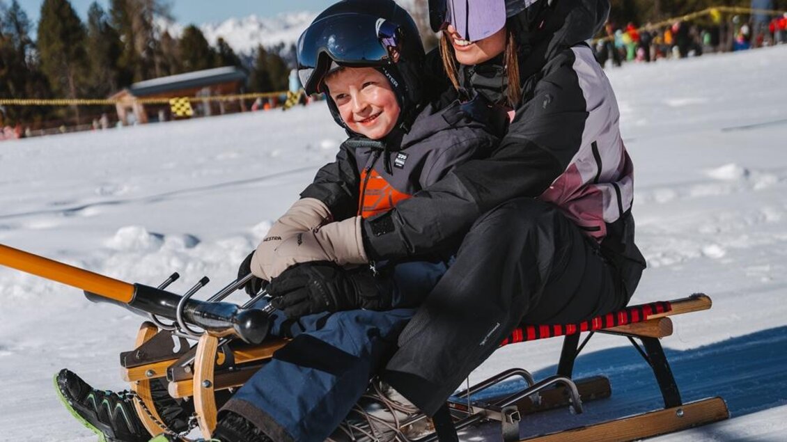 Frau und Kind sitzen am Schlitten und lassen sich vom Schlepplift ziehen. | © Tourismusverband Murau