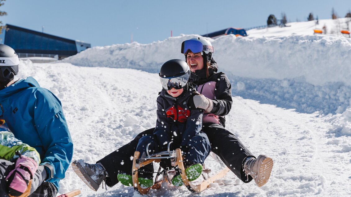 Frau und Kind fahren mit dem Schlitten rasant ins Tal. | © Tourismusverband Murau