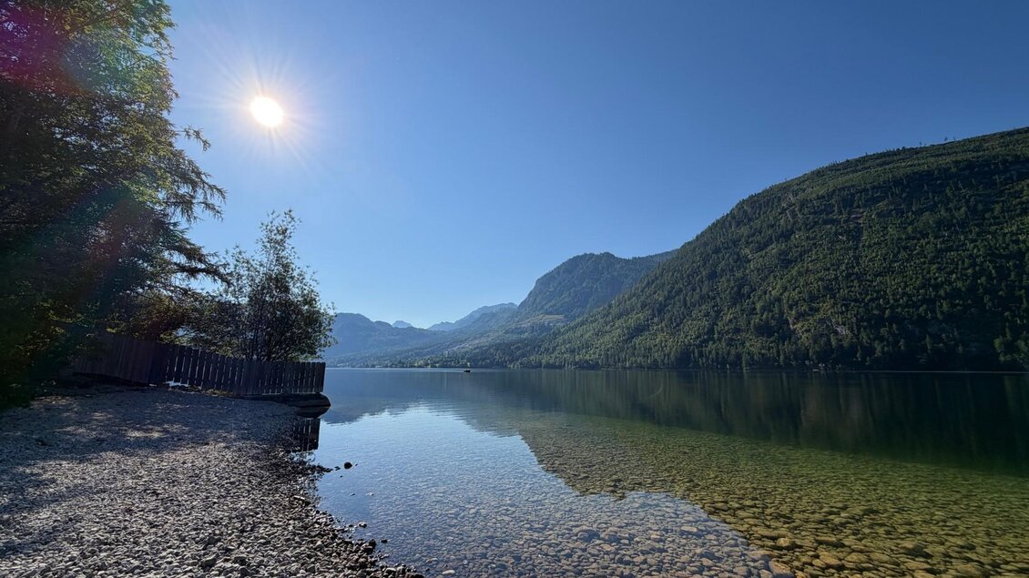 Ein ruhiger See mit klarem Wasser und einer wunderschönen Berglandschaft im Hintergrund. Die Sonne strahlt am blauen Himmel. | © Tourismusverband Ausseerland
