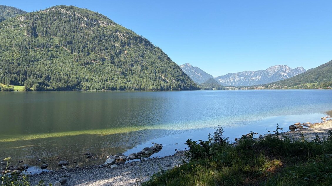 Der ruhige Grundlsee umgeben von den majestätischen Bergen des Toten Gebirges. Der Himmel ist klar und blau, ideal für ein entspanntes Ausflugsziel. | © Tourismusverband Ausseerland