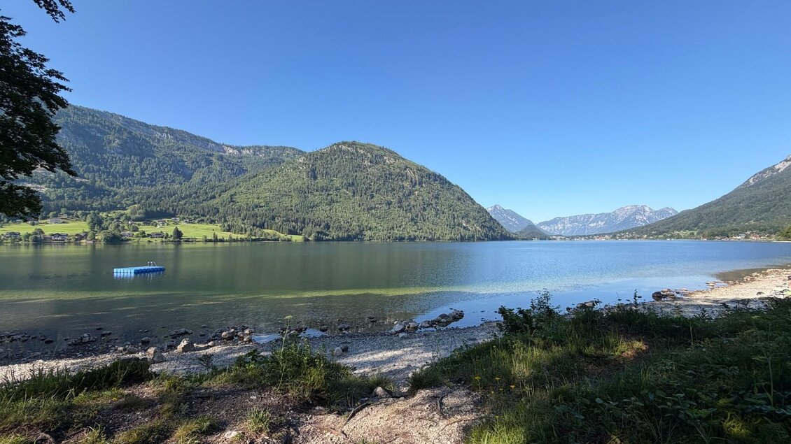 <p>Am Seeufer beim Grundlsee sind einige Steine und Pflanzen zu sehen. Vom Badeplatz Murboden kann der Ausblick bis zum Seeanfang genossen werden.</p> | © Tourismusverband Ausseerland