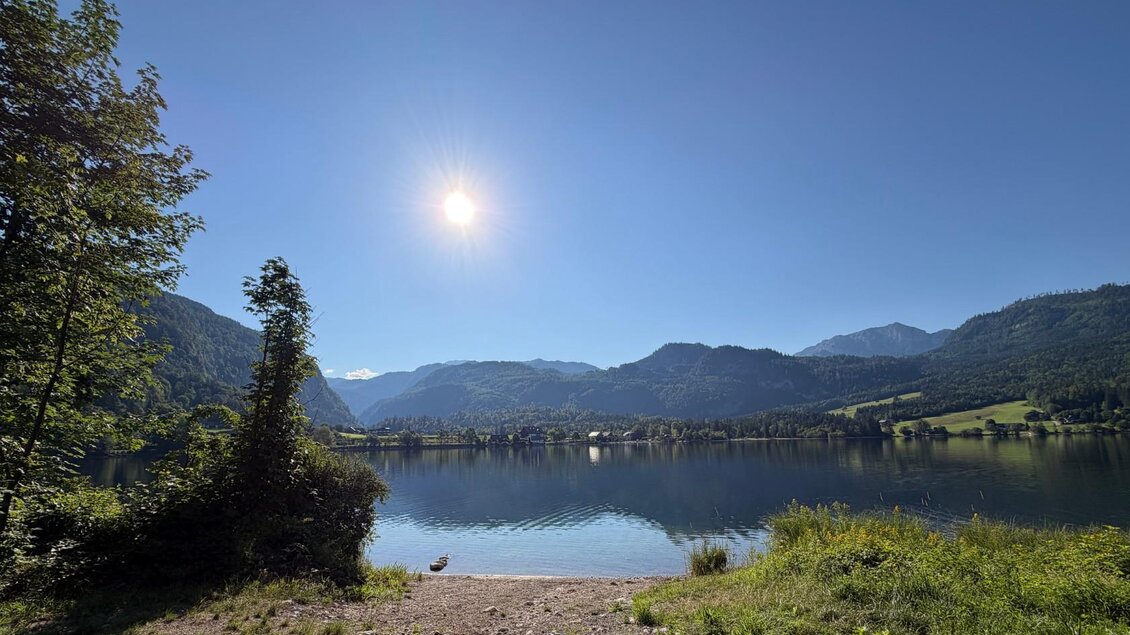 Der klare Grundlsee umgeben von dem majsetätischem Toten Gebirge. Die Sonne scheint hell am strahlend blauen Himmel. | © Tourismusverband Ausseerland