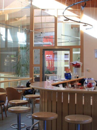 Das Sportstüberl mit der MiXed Bar in Bad Mitterndorf mit hellen Holzelementen und großen Fenstern. Die Einrichtung ist minimalistisch mit einer Bar und Sitzgelegenheiten gestaltet. | © Otwin Sparer