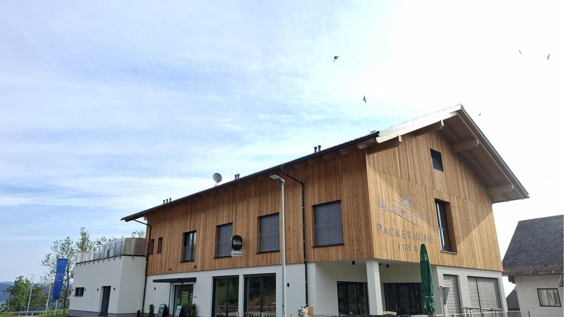 Modernes Gasthaus Packerhöhe mit Holzfassade und Gastgarten in Hirschegg-Pack. | © Region Graz_Astrid Lackner