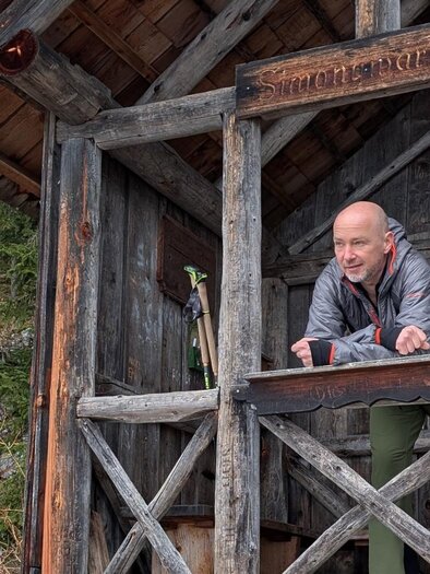 The mountain hiking guide stands in a hut on the Simonywarte. In the background, the local forest is visible.</p> | ©  Andreas Moser