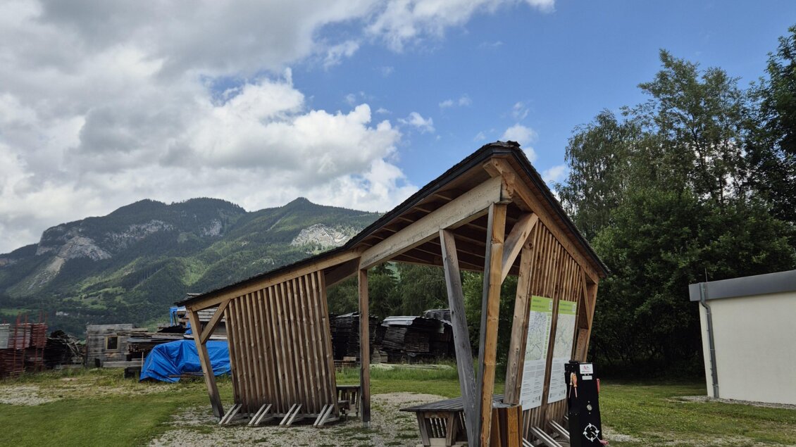 Eine Holzunterstand steht auf einer grünen Wiese mit Blick auf die Berge. Der Himmel ist bewölkt und es gibt einige Wolken. | © TVB Schladming-Dachstein