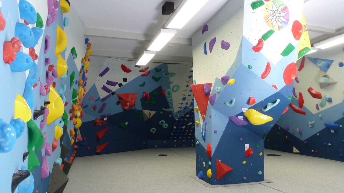 Kletterhalle des Österreichischen Alpenvereins Voitsberg mit geneigten Wänden, bunten Griffen und Boulderflächen im Innenbereich  | © Hans Fink