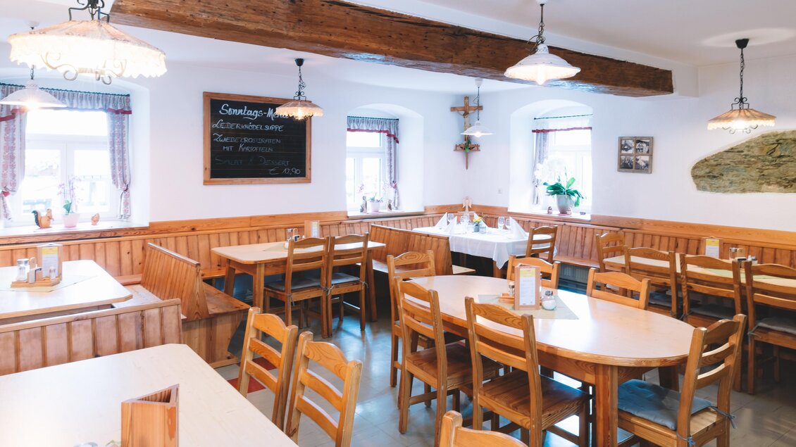 Ein gemütliches Restaurant mit Holzmöbeln und hellen Wänden. Tische sind ordentlich gedeckt und es gibt ausreichend Platz zum Sitzen. | © Dorfwirt Bratl