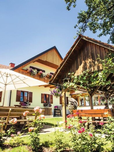 Ein einladendes Gasthaus mit einer schönen Terrasse. Blumenschmuck und Sonnenschirme schaffen eine gemütliche Atmosphäre im Freien. | © Schilcherland Steiermark