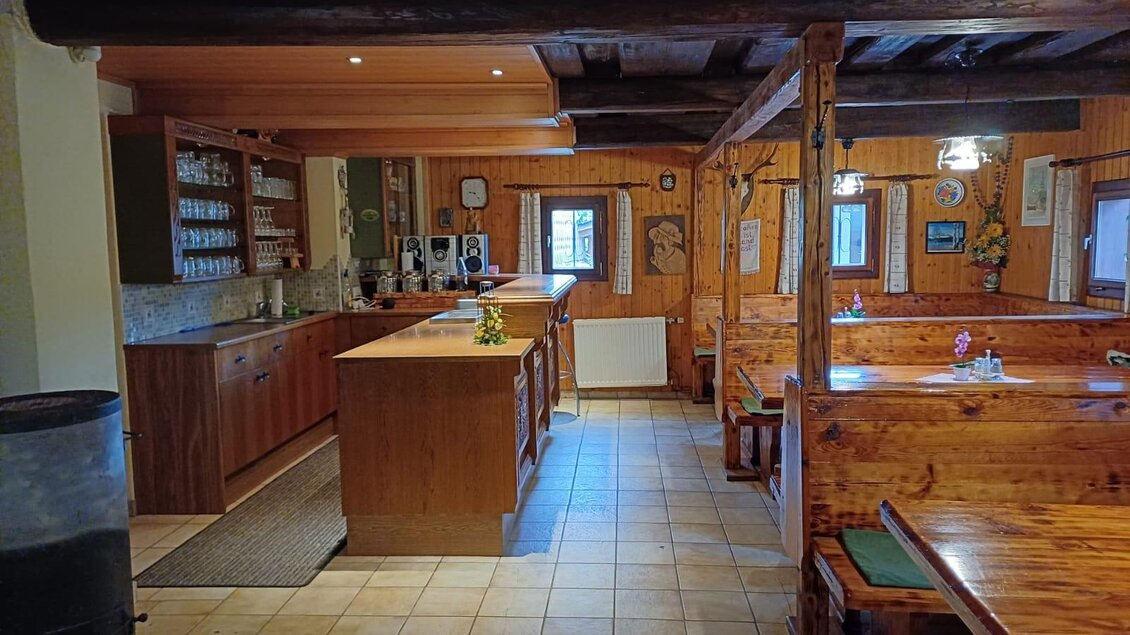 Ein gemütliches Restaurant mit Holzinterieur und Sitzbänken. Die Bar ist gut ausgestattet und der Raum hat eine warme, einladende Atmosphäre. | © Kraus-Ledinegg
