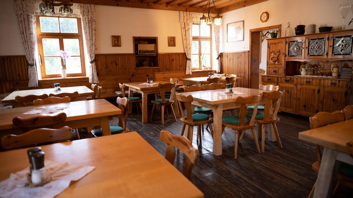 Ein gemütliches Restaurant mit Holztischen und Stühlen. Die Wände sind aus Holz, und es gibt große Fenster, die viel Licht hereinlassen. | © TV Südsteiermark - Dominik Feibel