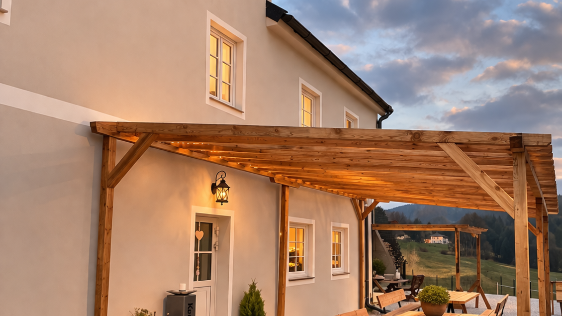 Ein gemütlicher Außenbereich mit Holztischen und Bänken vor einem hellen Gebäude. Die Atmosphäre ist warm und einladend, ideal für entspannte Stunden im Freien. | © Bio Hof Bichler