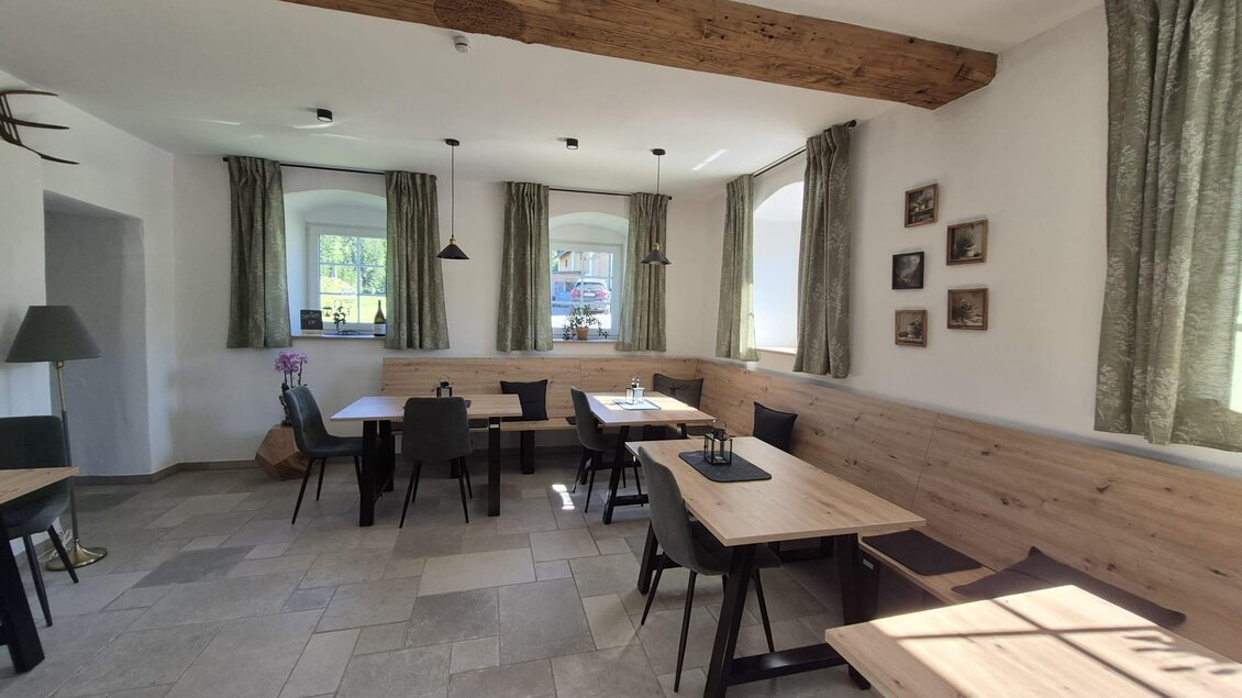 Ein gemütlicher Raum mit Holztischen und Stühlen. Große Fenster sorgen für viel Tageslicht und eine einladende Atmosphäre. | © TV Hochsteiermark