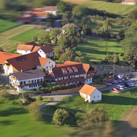 <p>Ein schönes ländliches Anwesen mit mehreren Gebäuden und roten Dächern. Umgeben von grünen Wiesen und Feldern. Buschenschank Papst in Bad Loipersdorf.</p> | © Buschenschank Papst
