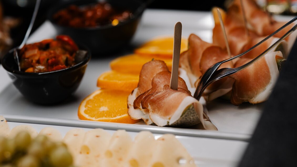 Ein schön angerichtetes Buffet mit verschiedenen Köstlichkeiten. Es gibt Schinken, Orangen, Trauben und verschiedene Dips in kleinen Schalen. | © Hotel Fohnsdorf  -  Cafè „Glück auf“