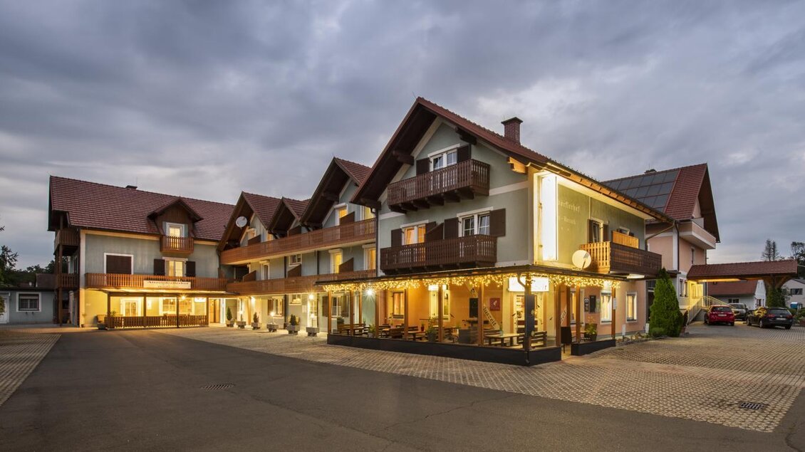 Ein charmantes Gebäude mit mehreren Etagen, das als Hotel oder Gasthaus dient. Die Fassade ist im traditionellen Stil gehalten und mit warmem Licht beleuchtet. | © Bachner Hotel BetriebsgesmbH