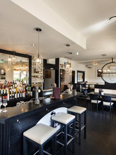 Ein modernes Restaurant mit einer eleganten Bar und stilvollen Stühlen. Die Atmosphäre ist hell und einladend, ideal für gesellige Treffen. | © Bachner Hotel BetriebsgesmbH