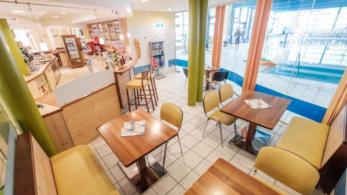 Ein modernes Café mit gemütlichen Tischen und Stühlen. Große Fenster bieten viel natürliches Licht und einen Blick nach draußen. | © Café Oase
