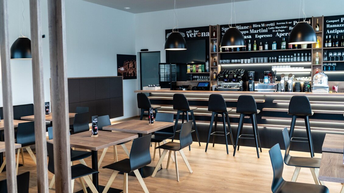 Heller Gastraum mit Sitzplätzen und Barbereich in der Café-Bar Verona in Voitsberg. | © Kalthuber photography