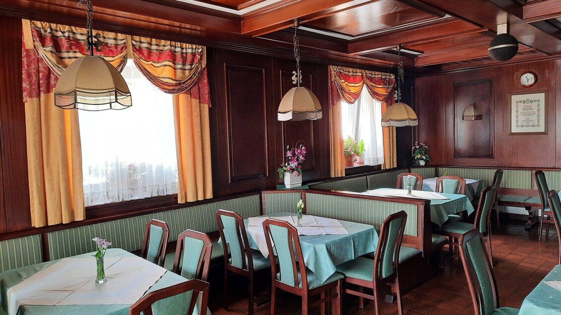 Gastraum des Restaurants Lorber in Köflach mit gedeckten Tischen, Holzvertäfelung, Stühlen und Fenstern mit Vorhängen. | © TV Region Graz-Reichnach