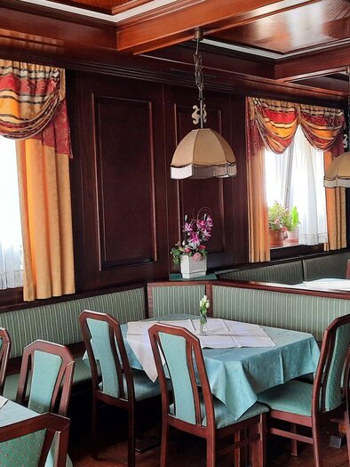 Gastraum des Restaurants Lorber in Köflach mit gedeckten Tischen, Holzvertäfelung, Stühlen und Fenstern mit Vorhängen. | © TV Region Graz-Reichnach