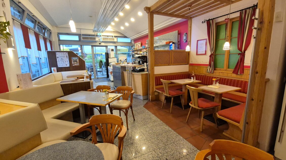 Ein gemütliches Café mit holzverkleidetem Interieur und bequemen Sitzgelegenheiten. Der Raum ist hell und einladend, mit Blick auf die Straße. | © TV Murau