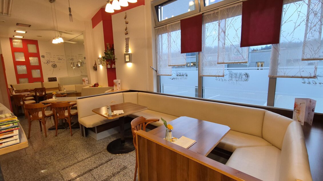 Ein gemütliches Café mit einem L-förmigen Sitzbereich und großen Fenstern. Die Wände sind in sanften Farben gehalten und es gibt eine entspannte Atmosphäre. | © TV Murau