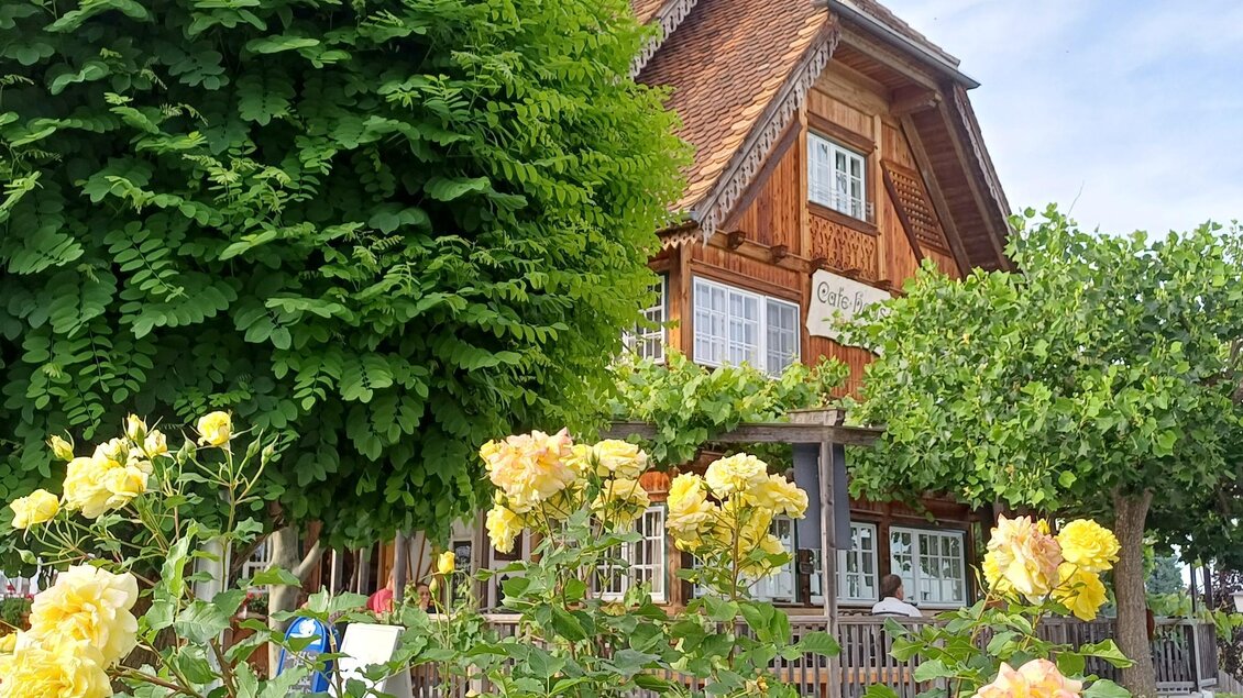 Ein charmantes Holzhaus umgeben von üppigem Grün. Im Vordergrund blühen gelbe Rosen. | © TV Südsteiermark - Löschnig Irene