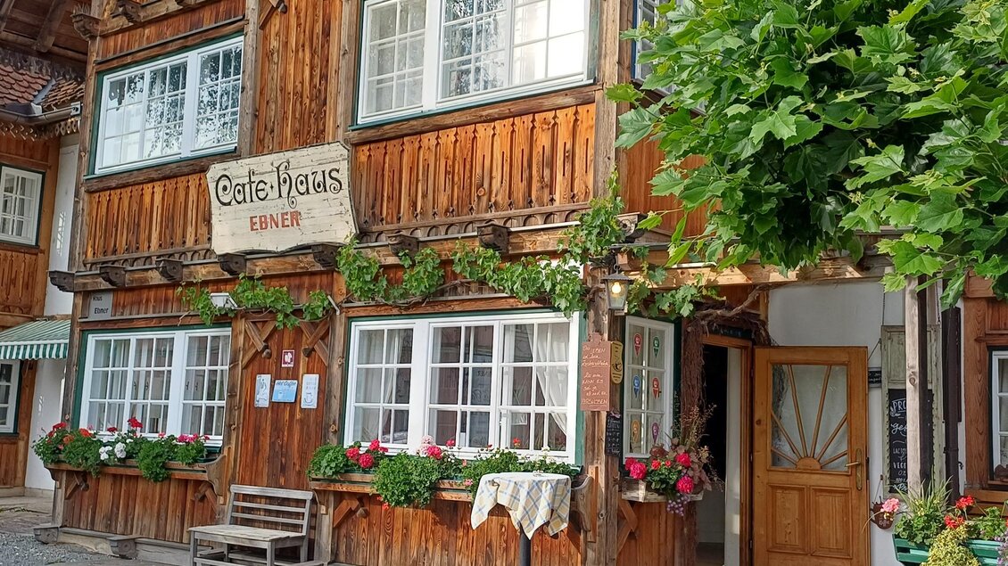 Ein charmantes Café-Haus mit Holzfassade und bunten Blumen vor den Fenstern. Der Eingang ist einladend und vermittelt eine gemütliche Atmosphäre. | © TV Südsteiermark - Löschnig Irene