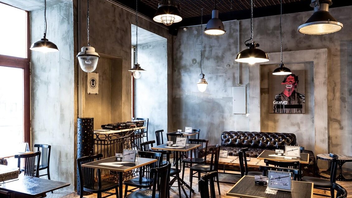 <p>Innenraum des Cafe Mitte in Graz mit Tischen, Stühlen, Ledersofa und Hängelampen im industriellen Design.</p> | © Cafe Mitte