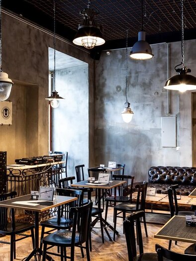 <p>Innenraum des Cafe Mitte in Graz mit Tischen, Stühlen, Ledersofa und Hängelampen im industriellen Design.</p> | © Cafe Mitte
