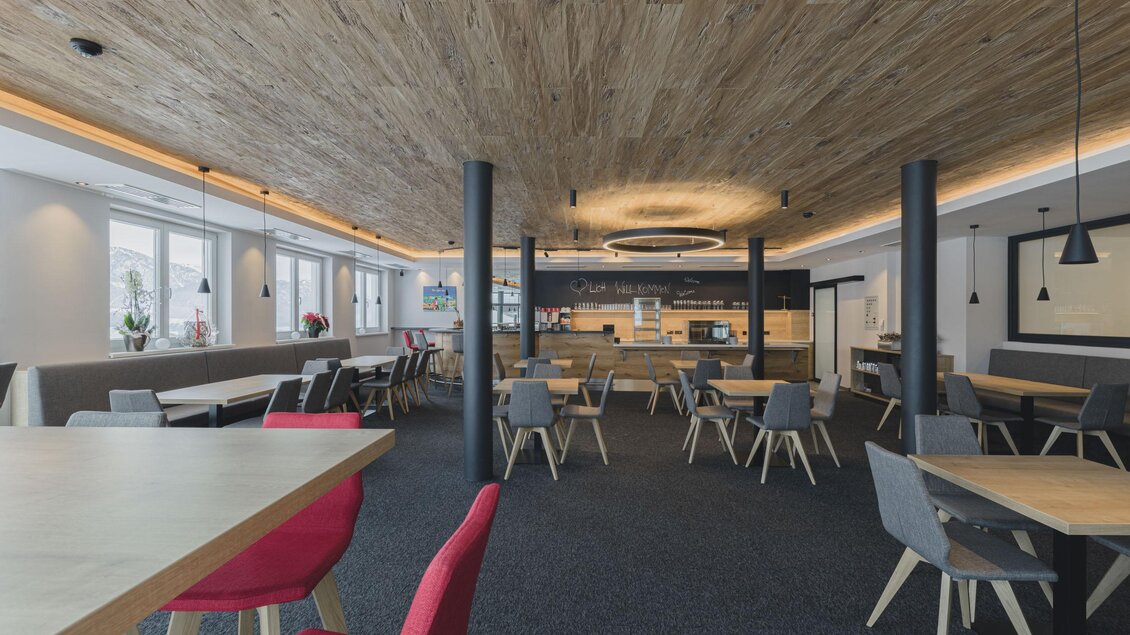 Ein modernes Café mit Holzdecke und gemütlichen Sitzbereichen. Die Einrichtung ist hell und einladend, ideal für entspannte Gespräche. | © Cafe Tritscher
