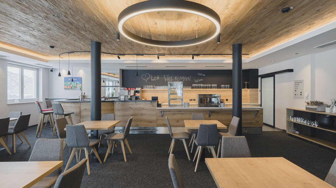 Ein modernes Café mit hellem Holzdekor und gemütlichen Tischen. Die Bar ist gut ausgestattet und es gibt eine einladende Atmosphäre. | © Cafe Tritscher