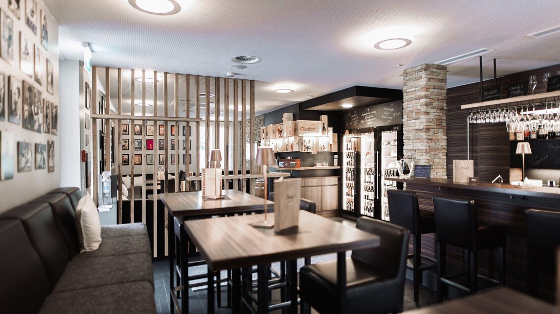 <p>Innenbereich von Charly's Café & Bar in Köflach mit Holztischen, Bar und Sitzbereich, moderne Café-Bar-Atmosphäre in der Steiermark.</p> | © Die Abbilderei