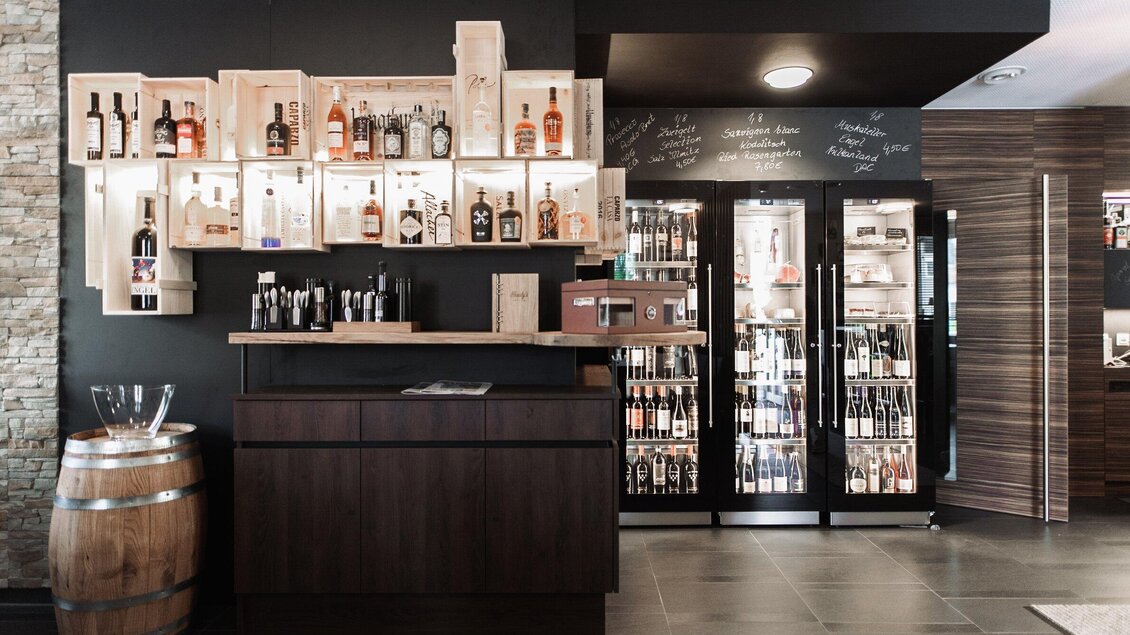 <p>Barbereich von Charly's Café & Bar in Köflach mit Spirituosenregalen, Zapfanlage und Kühlschränken, modernes Ambiente in der Steiermark.</p> | © Die Abbilderei