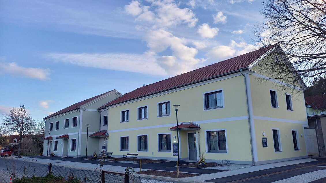<p>Ein modernes Gebäude mit gelber Fassade und roten Dächern. Der Himmel ist blau mit einigen Wolken. Haus der Gesundheit in Bad Blumau.</p> | © Thermen- & Vulkanland