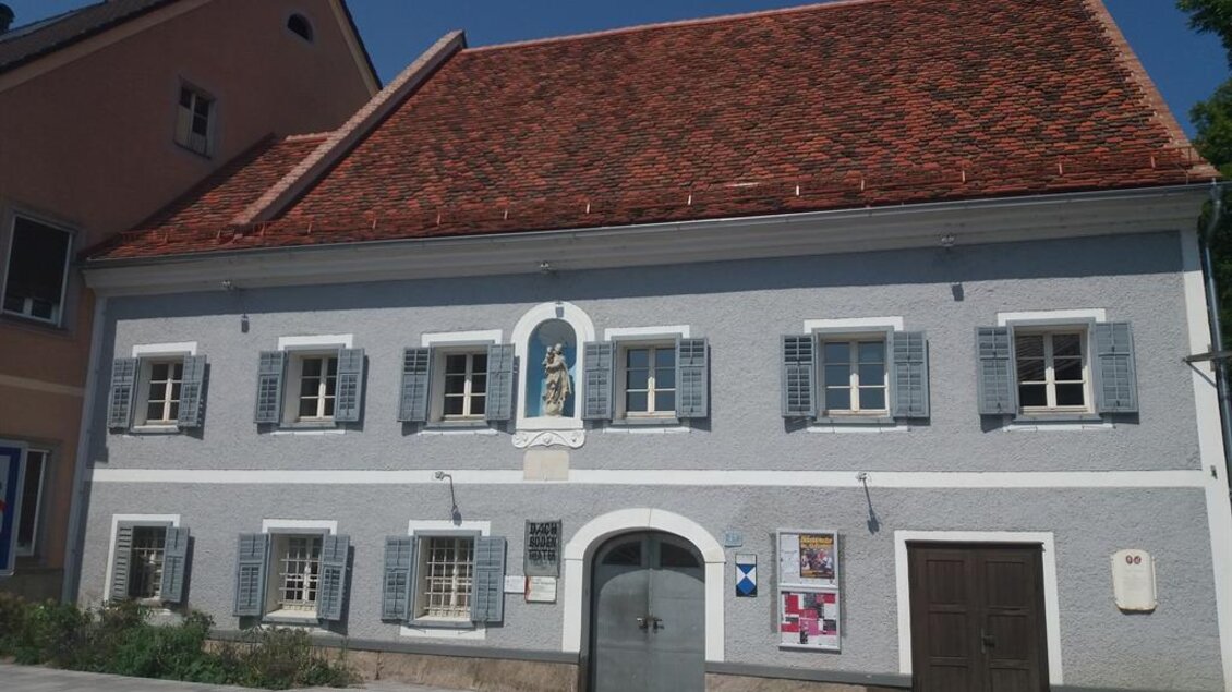 Ein historisches Gebäude mit blauer Fassade und roten Ziegeldach. Die Fenster sind mit Fensterläden versehen und im Eingangsbereich sind zwei Türen sichtbar. | © TV Südsteiermark - Irene Löschnig