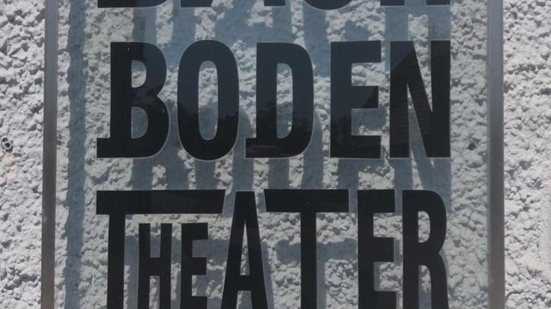 Ein Schild mit der Aufschrift „DACHBODEN THEATER“ befindet sich an einer grauen Wand. Darunter steht der Schriftzug „StainZeit“. | © StainZeit - Peter Nöhrer