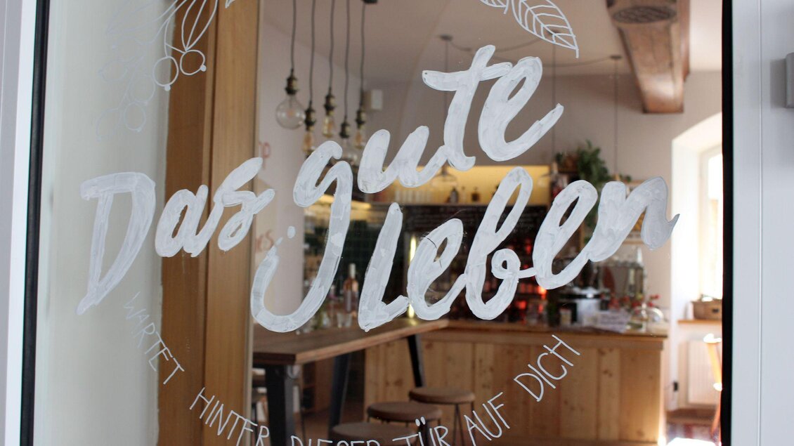 <p>Ein einladendes Café und Restaurant mit Holzinterieur. Auf der Glasscheibe der Tür steht der Schriftzug "Das gute Leben".</p> | © TVB Ausseerland Salzkammergut