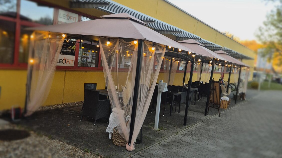 Einladende, überdachte Terrasse des Herzstückl in Bad Gleichenberg mit gemütlichen Sitzplätzen und stimmungsvoller Beleuchtung.

 | © Carina Feigl