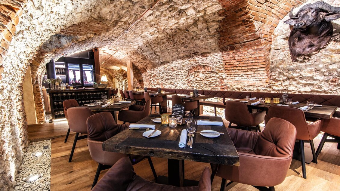 Ein stilvolles Restaurant mit gemütlichen, braunen Stühlen und einem rustikalen Backsteinarchitektur. Der Raum ist gut beleuchtet und bietet eine einladende Atmosphäre. | © Photoworkers