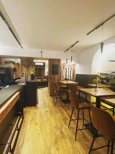 Ein stilvolles Restaurant mit Holzinterieur und modernen Stühlen. Die gemütliche Atmosphäre wird von sanftem Licht und einer ansprechenden Dekoration ergänzt. | © Der Südsteirer_Warasdin