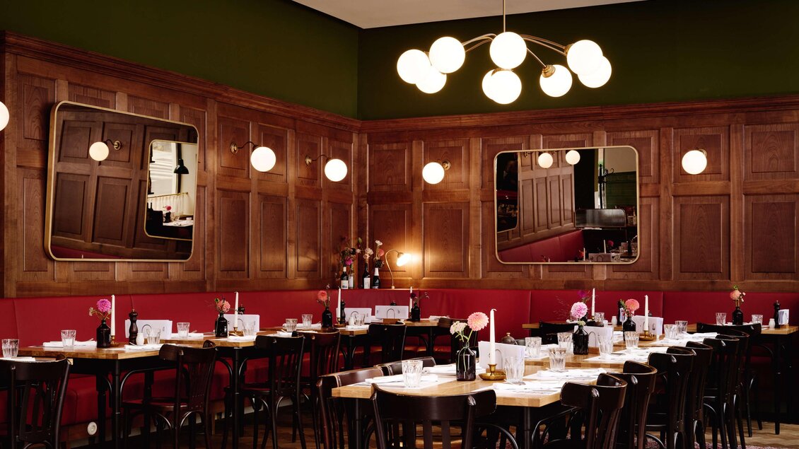 Gastraum des Restaurants Der Steirer in Graz mit gedeckten Tischen und Holzwandverkleidung. | © Florian Weitzer Hotels & Restaurants