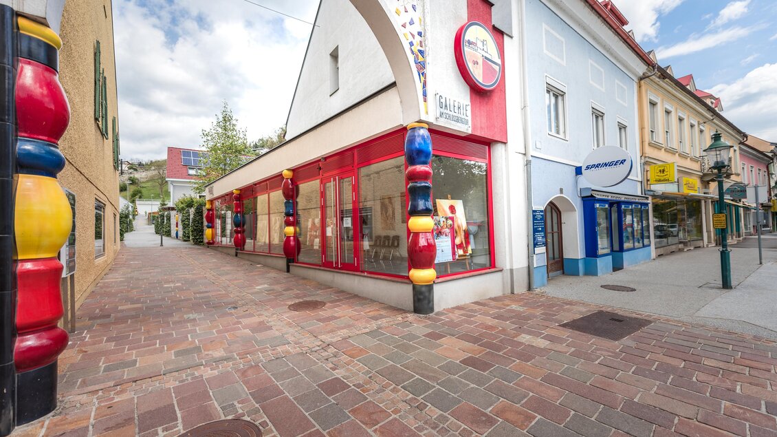 Außenansicht der Schlossberggalerie in der Voitsberger Innenstadt mit auffälligen bunten Säulen und angrenzender Fußgängerzone | © TV Region Graz - Die Abbilderei