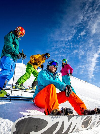 <p>A group of skiers and snowboarders on a snow-covered slope at the ski area "Die Tauplitz". The sky is clear and blue, with some clouds.</p> | © Die Tauplitz/Lamm